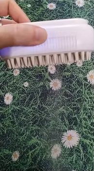 Customer photo: a hand holding the brush over a patterned rug